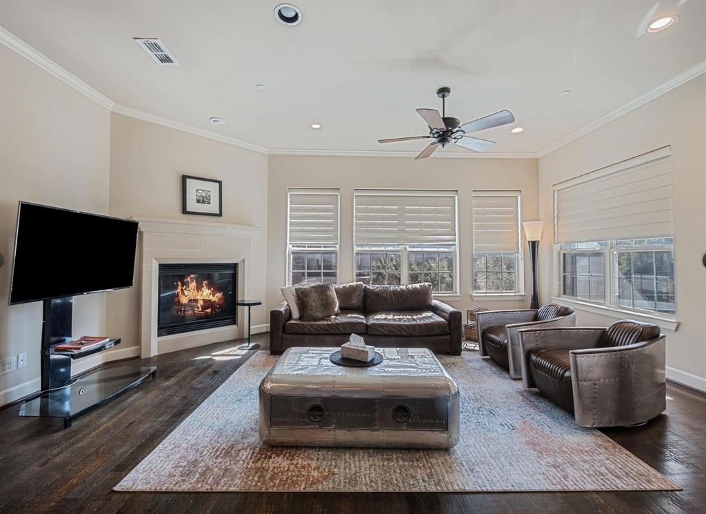 5001 Meridian Lane, Unit 2103 Addison, TX 75001 - Photo 5 of 26 Living area featuring wood-finish flooring, a white mantel fireplace, and multiple windows with blinds