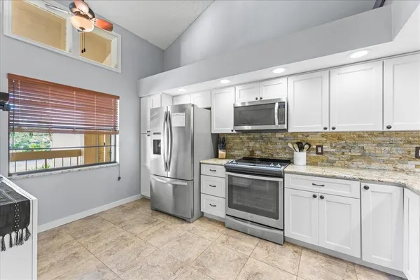 a kitchen with stainless steel appliances granite countertop a refrigerator stove and sink