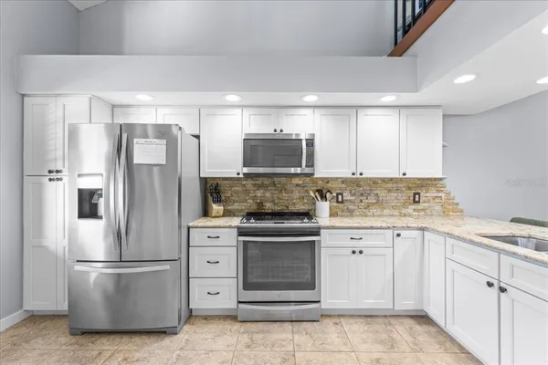 a kitchen with cabinets stainless steel appliances and a counter space