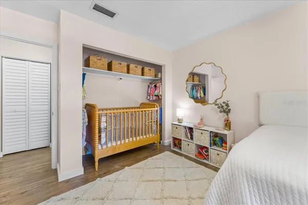 a view of a bedroom with baby crib and furniture
