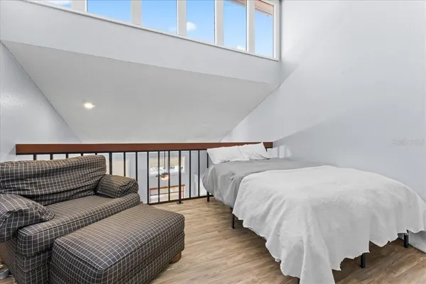 a bedroom with a bed and wooden floor