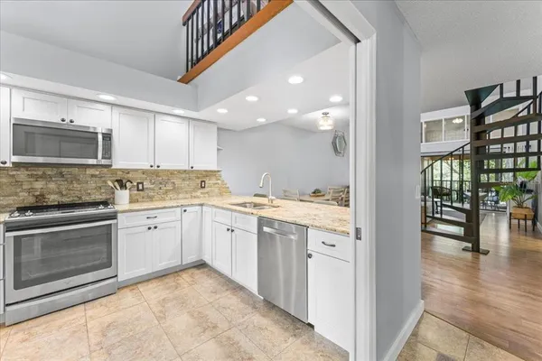 a kitchen with granite countertop a sink and cabinets