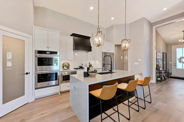 a large kitchen with a table chairs refrigerator and microwave