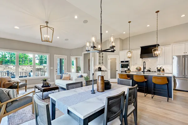 a view of kitchen with stainless steel appliances granite countertop a stove a kitchen island a dining table and chairs