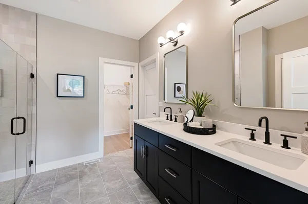 a bathroom with a double vanity sink a mirror and shower