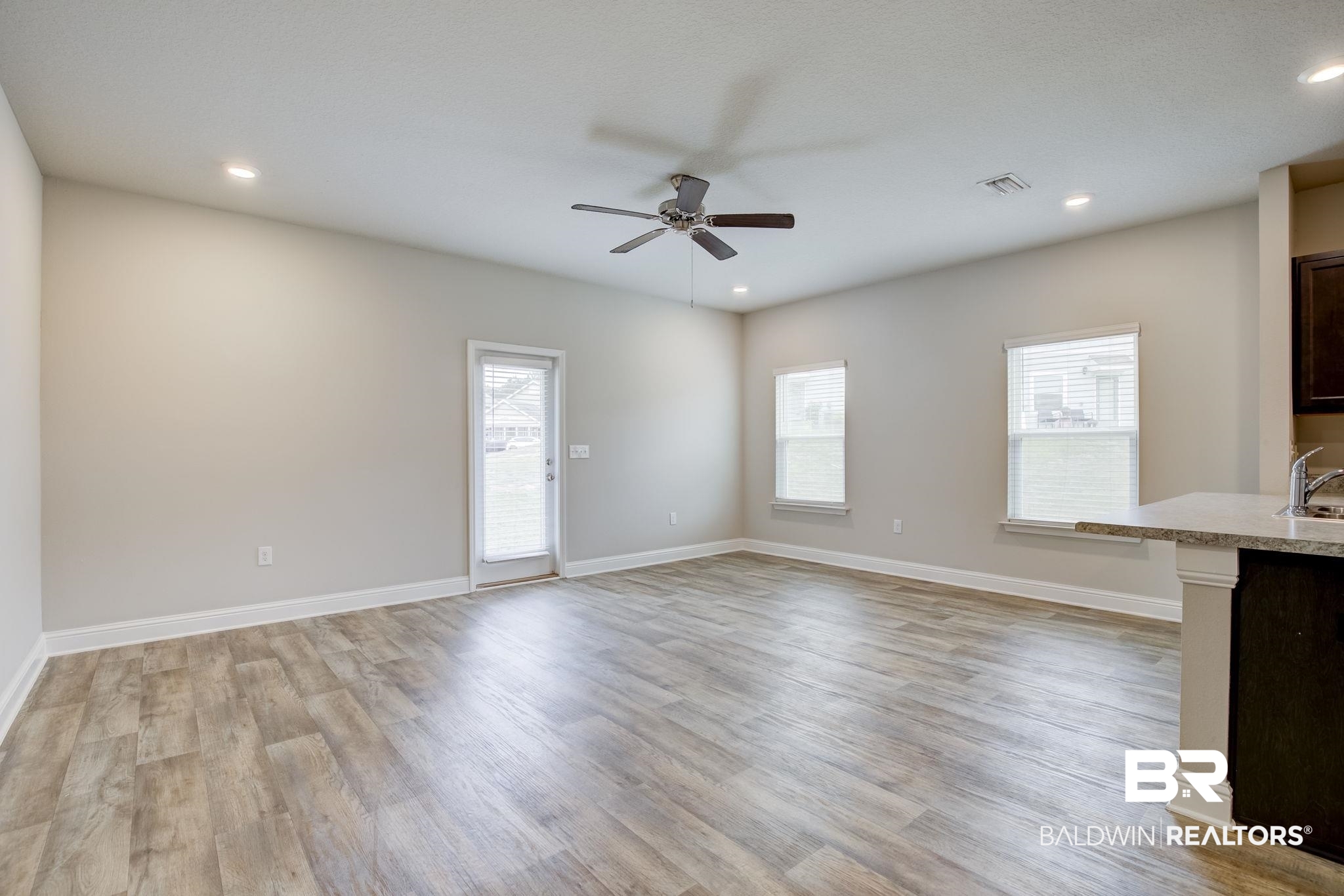 25806 Pollard Road, Unit 60 Daphne, AL 36526 - Photo 5 of 35 Unfurnished living room featuring ceiling fan, sink, and light hardwood / wood-style floors