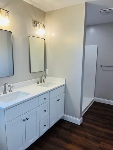 a bathroom with a double vanity sink and a mirror