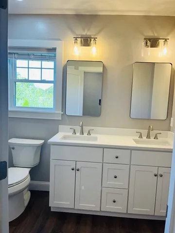 a bathroom with a toilet sink and mirror