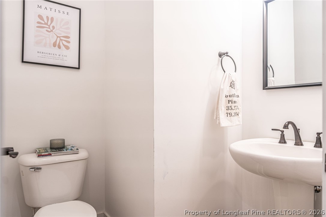 480 Clark Street Southern Pines, NC 28387 - Photo 12 of 28 a bathroom with a toilet sink and mirror