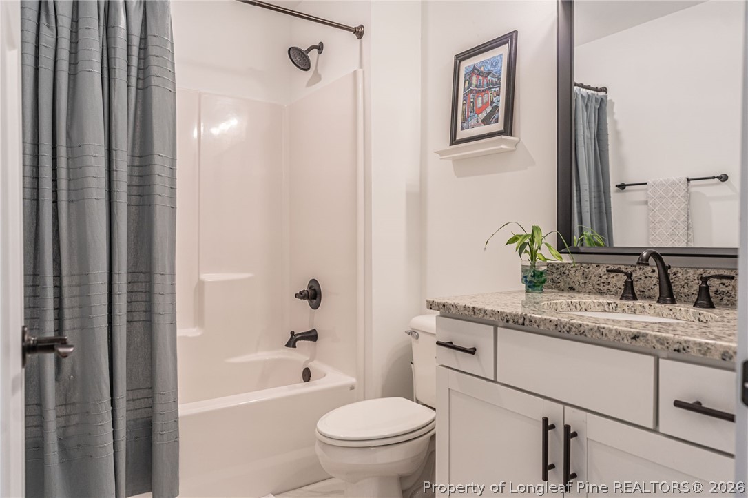 480 Clark Street Southern Pines, NC 28387 - Photo 15 of 28 a bathroom with a granite countertop sink toilet and shower