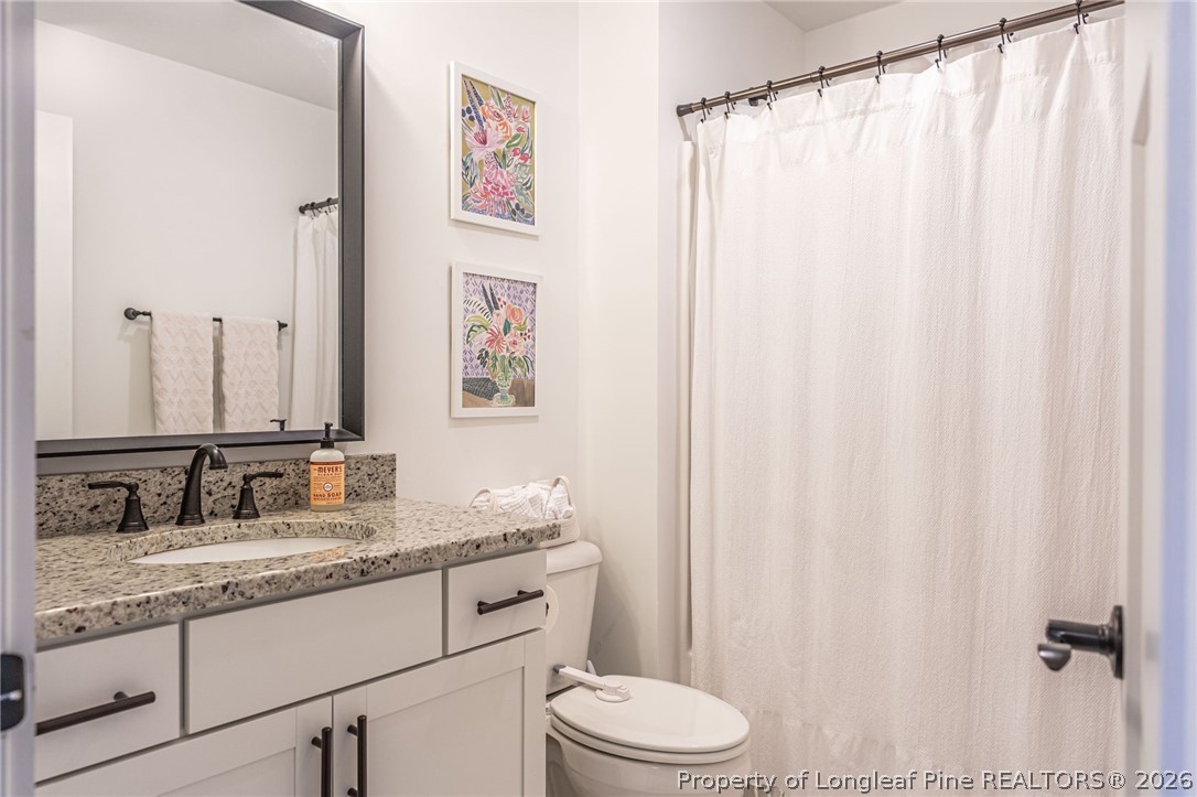 480 Clark Street Southern Pines, NC 28387 - Photo 19 of 28 a bathroom with a granite countertop sink and a mirror