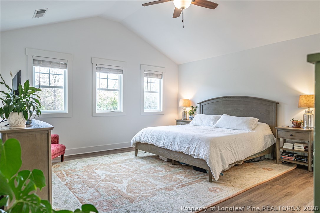 480 Clark Street Southern Pines, NC 28387 - Photo 20 of 28 a bedroom with a bed lamp and a potted plant