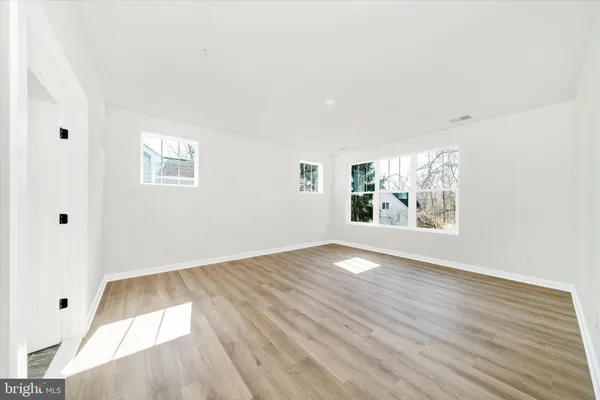 an empty room with windows and closet