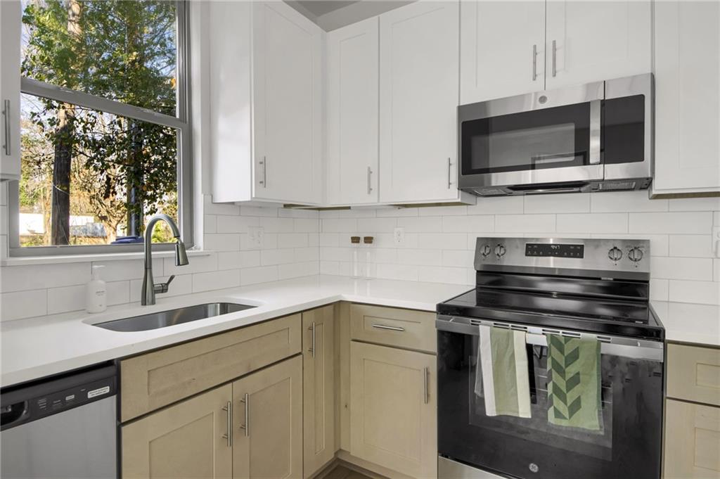 1070 Dill Avenue Southwest, Unit 306 Atlanta, GA 30310 - Photo 6 of 17 a kitchen with stainless steel appliances a stove sink and microwave