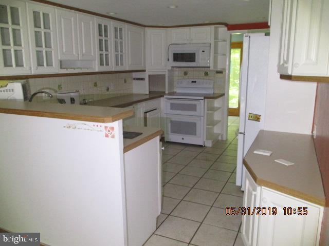 31 Springhill Road Mantua, NJ 08051 - Photo 3 of 16 a kitchen with granite countertop a refrigerator and a stove top oven
