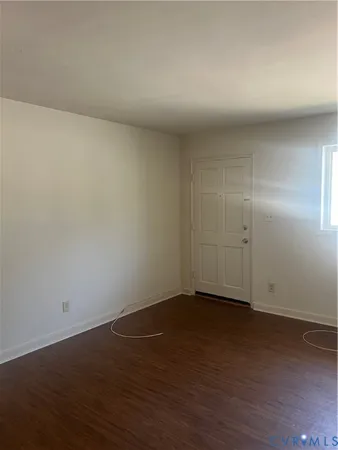 a view of an empty room and wooden floor