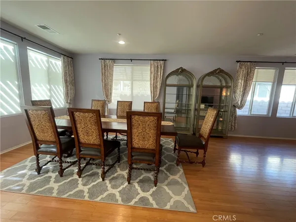 a kitchen with stainless steel appliances granite countertop a sink a stove a refrigerator cabinets and a dining table