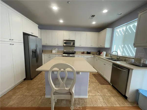 a kitchen with a sink a stove a refrigerator and cabinets