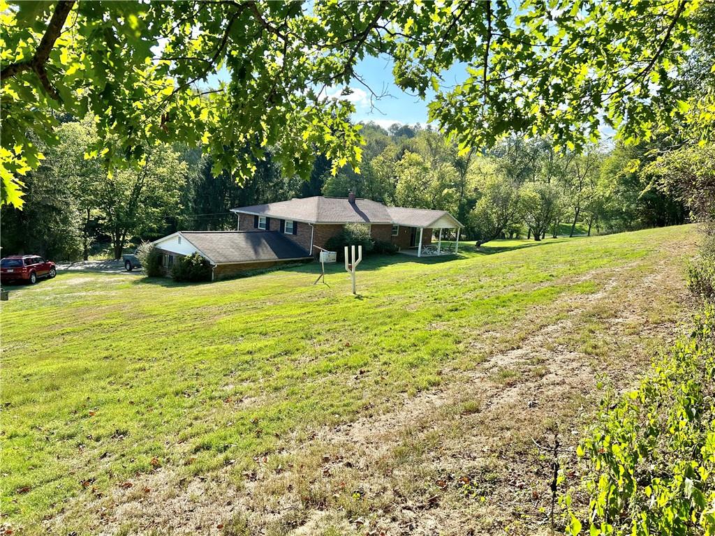 562 Smith Run Road Amity, PA 15311 - Photo 5 of 26 a view of a swimming pool with a lawn chairs under an umbrella