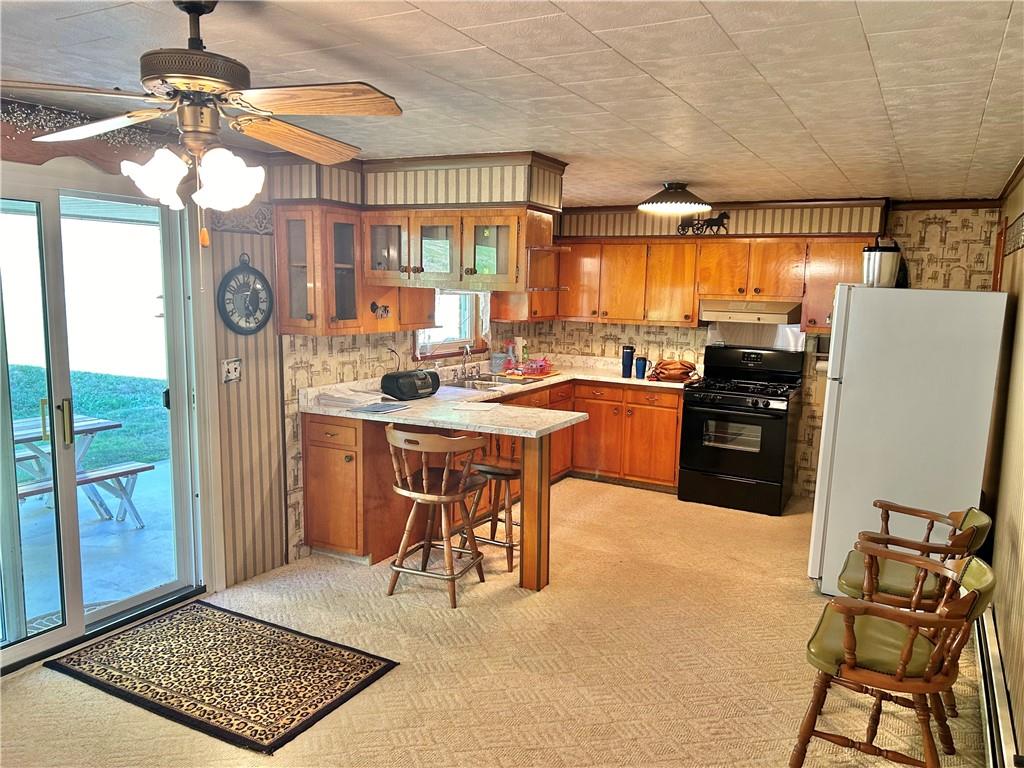 562 Smith Run Road Amity, PA 15311 - Photo 9 of 26 a kitchen with stainless steel appliances granite countertop a stove a refrigerator a sink a dining table and chairs with the bookshelf