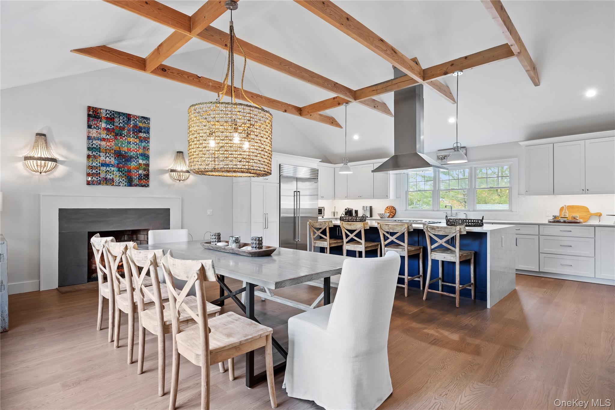 Dining room featuring beam ceiling, dark wood finished floors, high vaulted ceiling, a fireplace, and recessed lighting