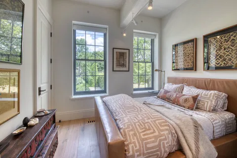 a bedroom with a bed and wooden floor