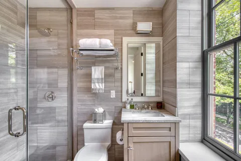 a bathroom with a granite countertop sink toilet and shower