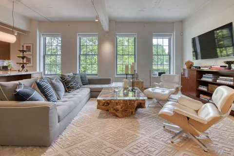 a living room with furniture large window and flat screen tv