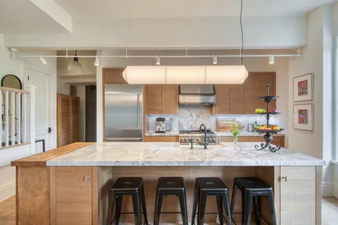 a kitchen with cabinets and wooden floor