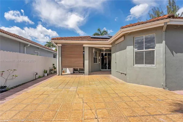 a view of a house with a yard and potted plants