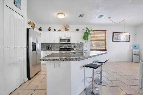 a kitchen with stainless steel appliances granite countertop a sink a refrigerator and a stove