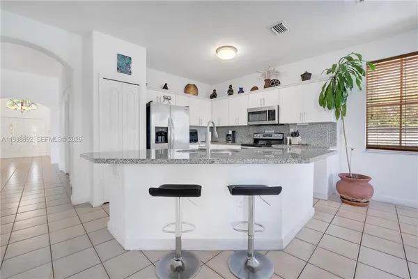 a kitchen with stainless steel appliances granite countertop a sink and a white cabinets