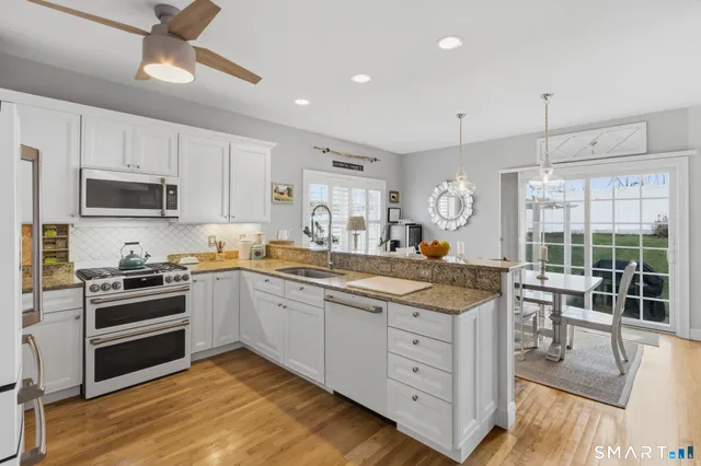 a kitchen with stainless steel appliances granite countertop a stove and cabinets