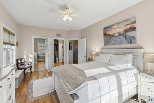a spacious bedroom with a bed a couch and a chandelier