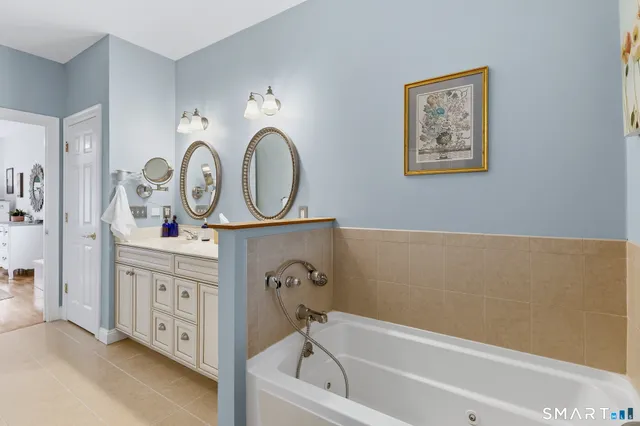 a bathroom with a bathtub sink and a mirror