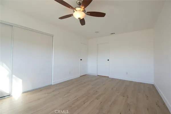 an empty room with a window and a ceiling fan