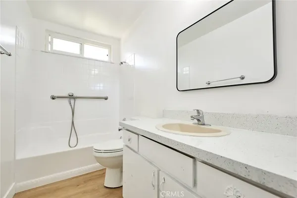 a bathroom with a granite countertop sink a toilet and a mirror