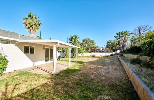 a view of a house with backyard and sitting area