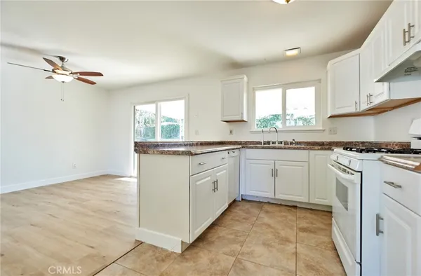 a kitchen with granite countertop white cabinets white appliances with a sink and dishwasher