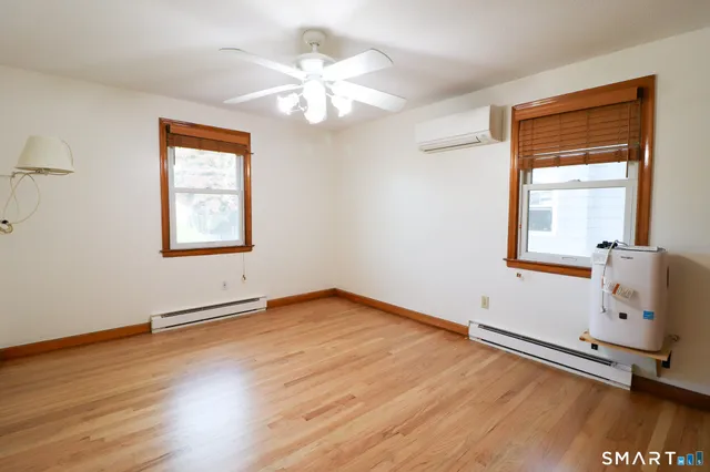 a view of an empty room with window and a ceiling fan
