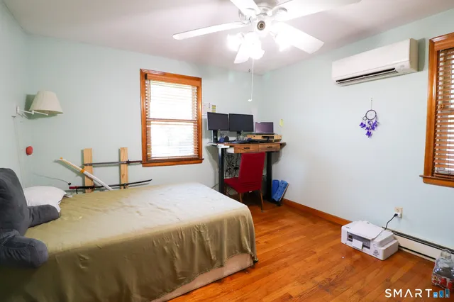 a bedroom with a bed and wooden floor
