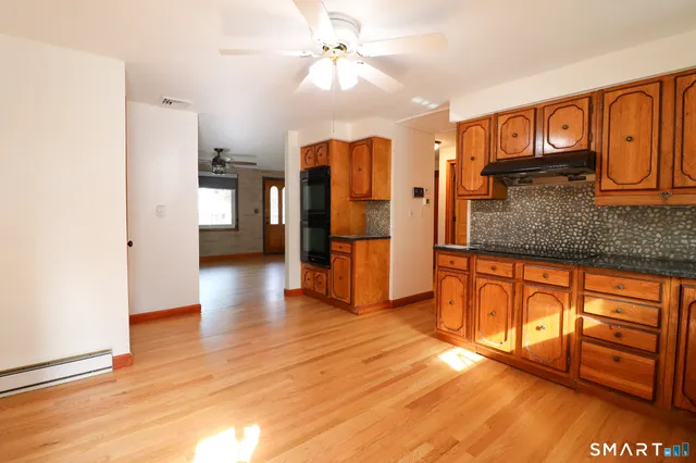 a large kitchen with stainless steel appliances granite countertop a sink and cabinets