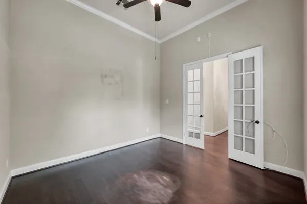 an empty room with a hardwood and ceiling fan