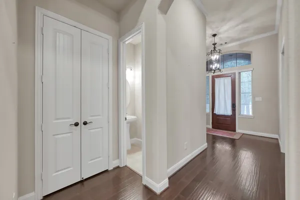 a view of a hallway with wooden floor and closet