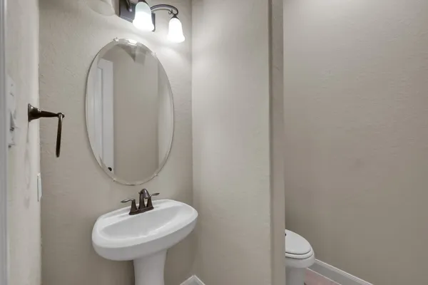 a bathroom with a sink toilet and a mirror