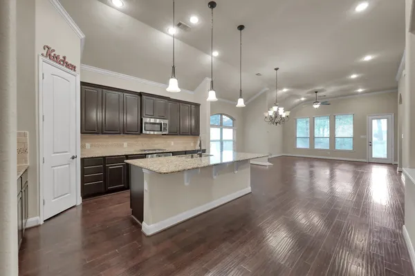 a large kitchen with lots of counter space a sink appliances and cabinets