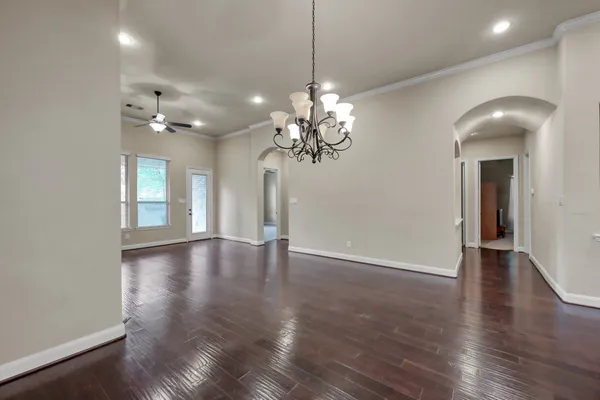 a view of a livingroom with a chandelier fan and windows