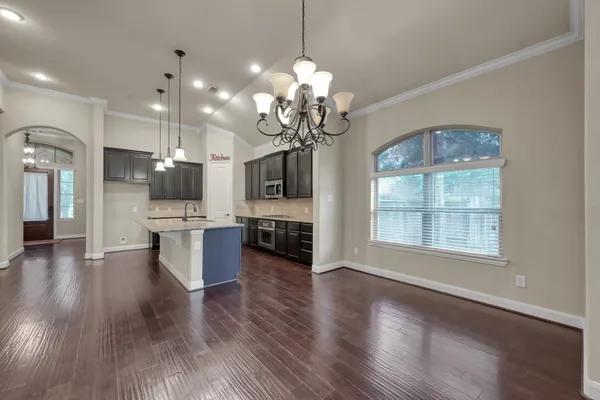 a view of a kitchen with cabinets and wooden floor