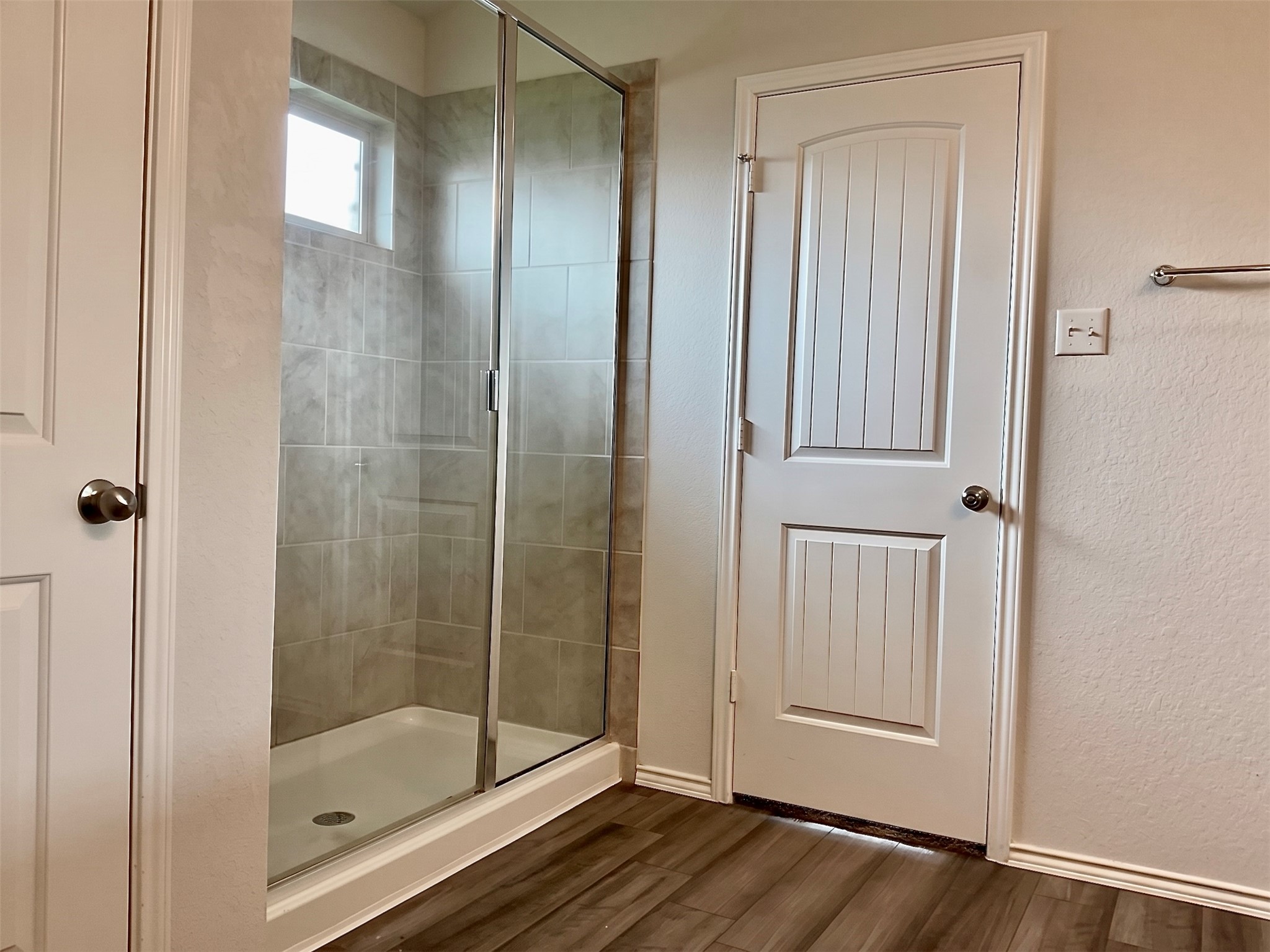 124 Marcel Court Taylor, TX 76574 - Photo 9 of 17 Primary bathroom with wood look vinyl plank an large step-in shower