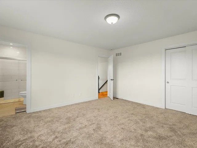 a living room with couches and painting on the wall with wooden floor